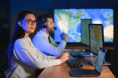 Tamirat merkezi. Seyrüsefer kontrol panosunda otururken kulaklıkla çalışan neşeli kadın ve erkek portresi.