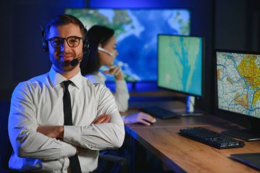 Tamirat merkezi. Seyrüsefer kontrol panosunda otururken kulaklıkla çalışan neşeli kadın ve erkek portresi.