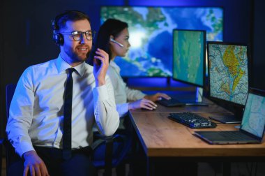 Tamirat merkezi. Seyrüsefer kontrol panosunda otururken kulaklıkla çalışan neşeli kadın ve erkek portresi.