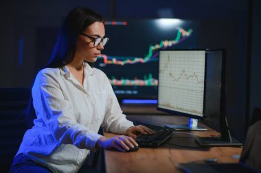 Kadın tüccar. Bayan bilgisayarla yatırım yapıyor. İş kadını hisse senedi fiyatlarını takip ediyor.