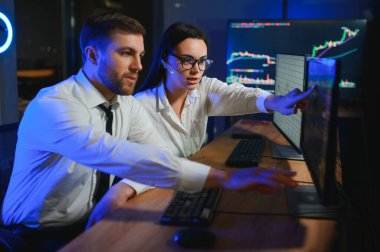 İşletme takımı yatırımı bilgisayarla çalışıyor, borsa işlemlerini planlıyor ve analiz ediyor..