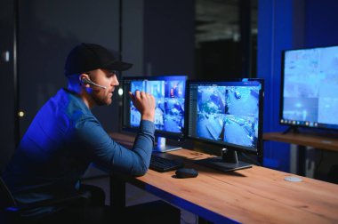 Erkek güvenlik görevlisi gözetim odasında.