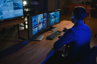 Güvenlik operatörü gece ofisindeki güvenlik kameralarını kontrol ediyor. Modern güvenlik sistemi ve sosyal güvenlik kavramı.