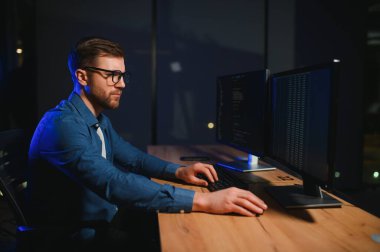 Ofiste masa başında çalışan programcı.