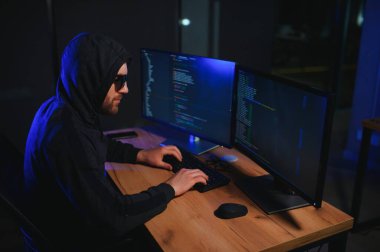 Bilgisayar ve dizüstü bilgisayar kullanarak virüs fidye virüsü kodlayan aranan hackerlar. Siber saldırı, sistem kırma ve kötü amaçlı yazılım kavramı.