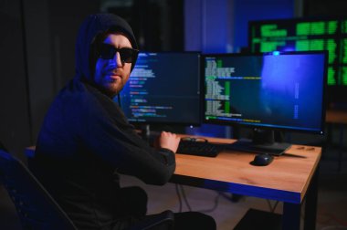 Bilgisayar ve dizüstü bilgisayar kullanarak virüs fidye virüsü kodlayan aranan hackerlar. Siber saldırı, sistem kırma ve kötü amaçlı yazılım kavramı.