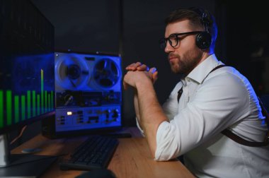 Gizli ajan kayıt cihazını dinliyormuş. Memur kulaklıkla dinleme yapıyor. Muhabbet casusluğu. İstihbarat toplama. Casusluk konsepti.