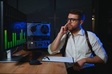 Gizli ajan kayıt cihazını dinliyormuş. Memur kulaklıkla dinleme yapıyor. Muhabbet casusluğu. İstihbarat toplama. Casusluk konsepti.