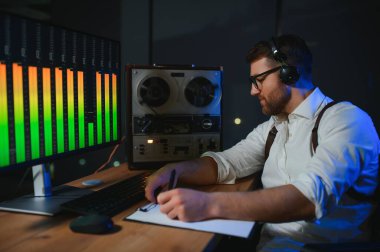 Gizli ajan kayıt cihazını dinliyormuş. Memur kulaklıkla dinleme yapıyor. Muhabbet casusluğu. İstihbarat toplama. Casusluk konsepti.