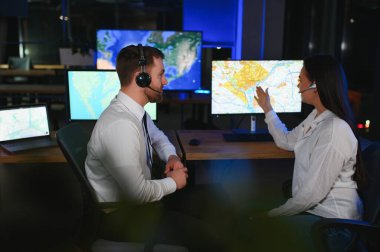 Tamirat merkezi. Seyrüsefer kontrol panosunda otururken kulaklıkla çalışan neşeli kadın ve erkek portresi.