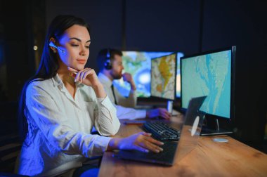 Tamirat merkezi. Seyrüsefer kontrol panosunda otururken kulaklıkla çalışan neşeli kadın ve erkek portresi.