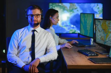 Tamirat merkezi. Seyrüsefer kontrol panosunda otururken kulaklıkla çalışan neşeli kadın ve erkek portresi.