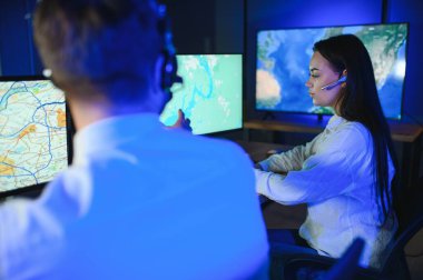 Tamirat merkezi. Seyrüsefer kontrol panosunda otururken kulaklıkla çalışan neşeli kadın ve erkek portresi.