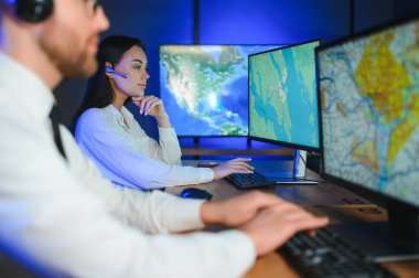 Gülümseyen arkadaş canlısı çağrı merkezi ajanı, kulaklıkla ofiste yardım hattında çalışıyor..