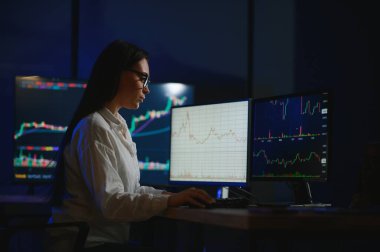 Kadın tüccar. Bayan bilgisayarla yatırım yapıyor. İş kadını hisse senedi fiyatlarını takip ediyor.