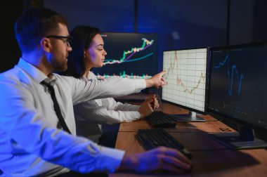 İşletme takımı yatırımı bilgisayarla çalışıyor, borsa işlemlerini planlıyor ve analiz ediyor..