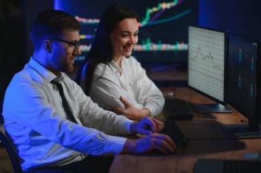 İşletme takımı yatırımı bilgisayarla çalışıyor, borsa işlemlerini planlıyor ve analiz ediyor..