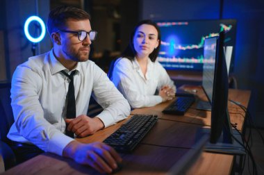 İşletme takımı yatırımı bilgisayarla çalışıyor, borsa işlemlerini planlıyor ve analiz ediyor..