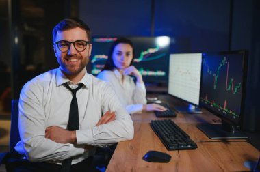 İşletme takımı yatırımı bilgisayarla çalışıyor, borsa işlemlerini planlıyor ve analiz ediyor..