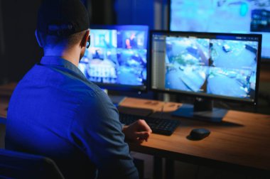 Güvenlik operatörü gece ofisindeki güvenlik kameralarını kontrol ediyor. Modern güvenlik sistemi ve sosyal güvenlik kavramı.