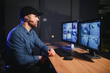 Erkek güvenlik görevlisi gözetim odasında.