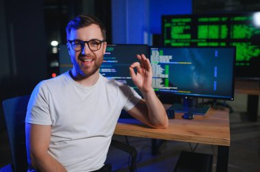 Gece Ofisi: Masaüstü Bilgisayarında Çalışan Genç Yakışıklı Adam. Dijital Girişimci Daktilo Kodu, Modern Yazılım Geliştirme, E-Ticari Uygulama Tasarımı, E-İş Geliştirme. Omuz üstünden.