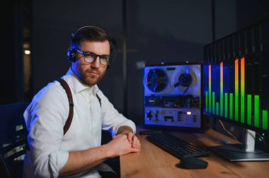 Gizli ajan kayıt cihazını dinliyormuş. Memur kulaklıkla dinleme yapıyor. Muhabbet casusluğu. İstihbarat toplama. Casusluk konsepti.