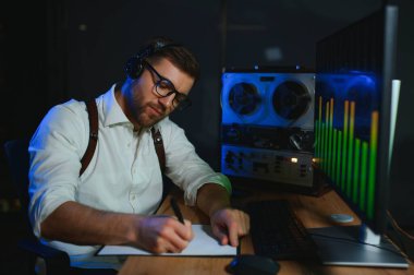 Gizli ajan kayıt cihazını dinliyormuş. Memur kulaklıkla dinleme yapıyor. Muhabbet casusluğu. İstihbarat toplama. Casusluk konsepti.