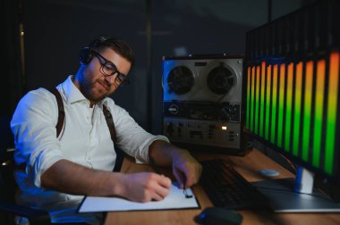 Gizli ajan kayıt cihazını dinliyormuş. Memur kulaklıkla dinleme yapıyor..