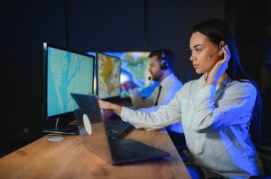 Tamirat merkezi. Seyrüsefer kontrol panosunda otururken kulaklıkla çalışan neşeli kadın ve erkek portresi.