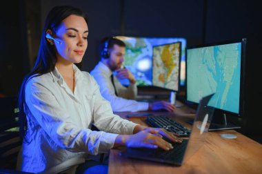 Tamirat merkezi. Seyrüsefer kontrol panosunda otururken kulaklıkla çalışan neşeli kadın ve erkek portresi.