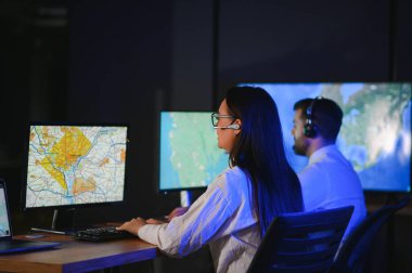 Tamirat merkezi. Seyrüsefer kontrol panosunda otururken kulaklıkla çalışan neşeli kadın ve erkek portresi.