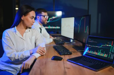 İşletme takımı yatırımı bilgisayarla çalışıyor, borsa işlemlerini planlıyor ve analiz ediyor..