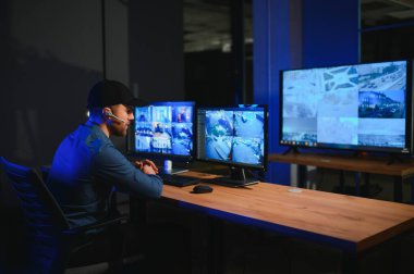 Güvenlik operatörü gece ofisindeki güvenlik kameralarını kontrol ediyor. Modern güvenlik sistemi ve sosyal güvenlik kavramı.