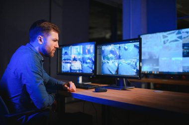 Güvenlik operatörü gece ofisindeki güvenlik kameralarını kontrol ediyor. Modern güvenlik sistemi ve sosyal güvenlik kavramı.