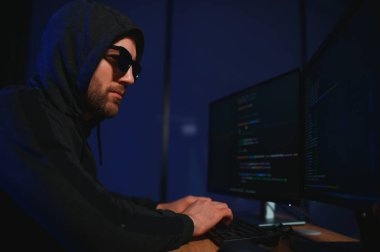 Bilgisayar ve dizüstü bilgisayar kullanarak virüs fidye virüsü kodlayan aranan hackerlar. Siber saldırı, sistem kırma ve kötü amaçlı yazılım kavramı.