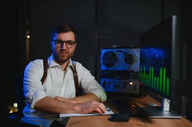 Gizli ajan kayıt cihazını dinliyormuş. Memur kulaklıkla dinleme yapıyor..