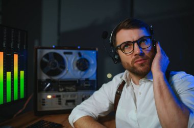 Gizli ajan kayıt cihazını dinliyormuş. Memur kulaklıkla dinleme yapıyor. Muhabbet casusluğu. İstihbarat toplama. Casusluk konsepti.