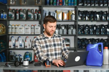 Oto yedek parça dükkanındaki yakışıklı bir satıcının portresi. Araba tamiri kavramı.