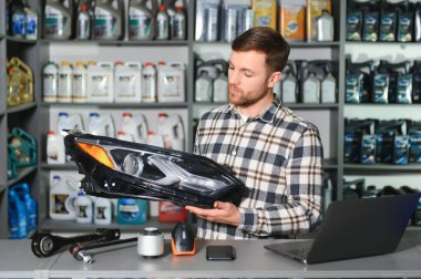 Otomobil yedek parça mağazasında adamın farları var..