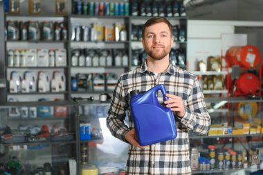 Otomobil deposunda motor yağı kutusu olan bir satıcı..