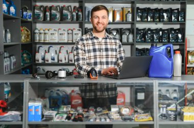 Oto yedek parça dükkanındaki yakışıklı bir satıcının portresi. Araba tamiri kavramı.