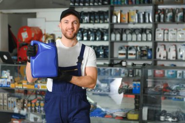 Otomobil deposunda motor yağı kutusu olan bir satıcı..