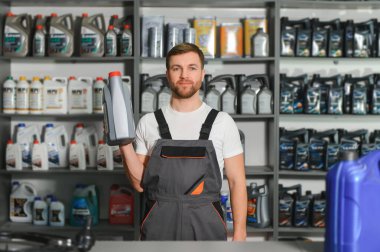 Otomobil deposunda motor yağı kutusu olan bir satıcı..