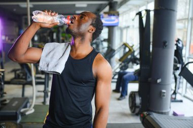 Spor salonunda egzersiz yapmaya hazırlanan genç bir Afro-Amerikalı..