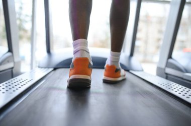 Spor salonunda koşu bandı üzerinde çalışan tanınmaz erkek bacakları arkadan görünüm. Erkek fit fitness kulübünde koşu. Sağlıklı yaşam konsepti