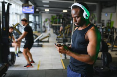 Spor salonunda dikilen Afrikalı Amerikalı bir adam..