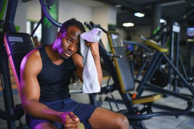 Sağlık kulübünde havlusu olan düşünceli bir genç adam..