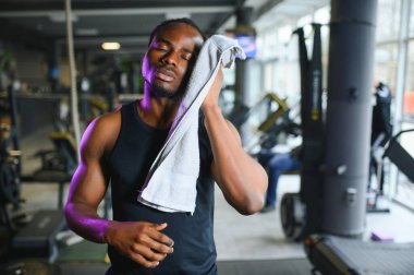Spor salonunda egzersiz yapmaya hazırlanan genç bir Afro-Amerikalı..