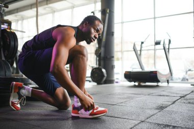 Spor salonunda ayakkabı bağcıklarını bağlayan Afrikalı adam..